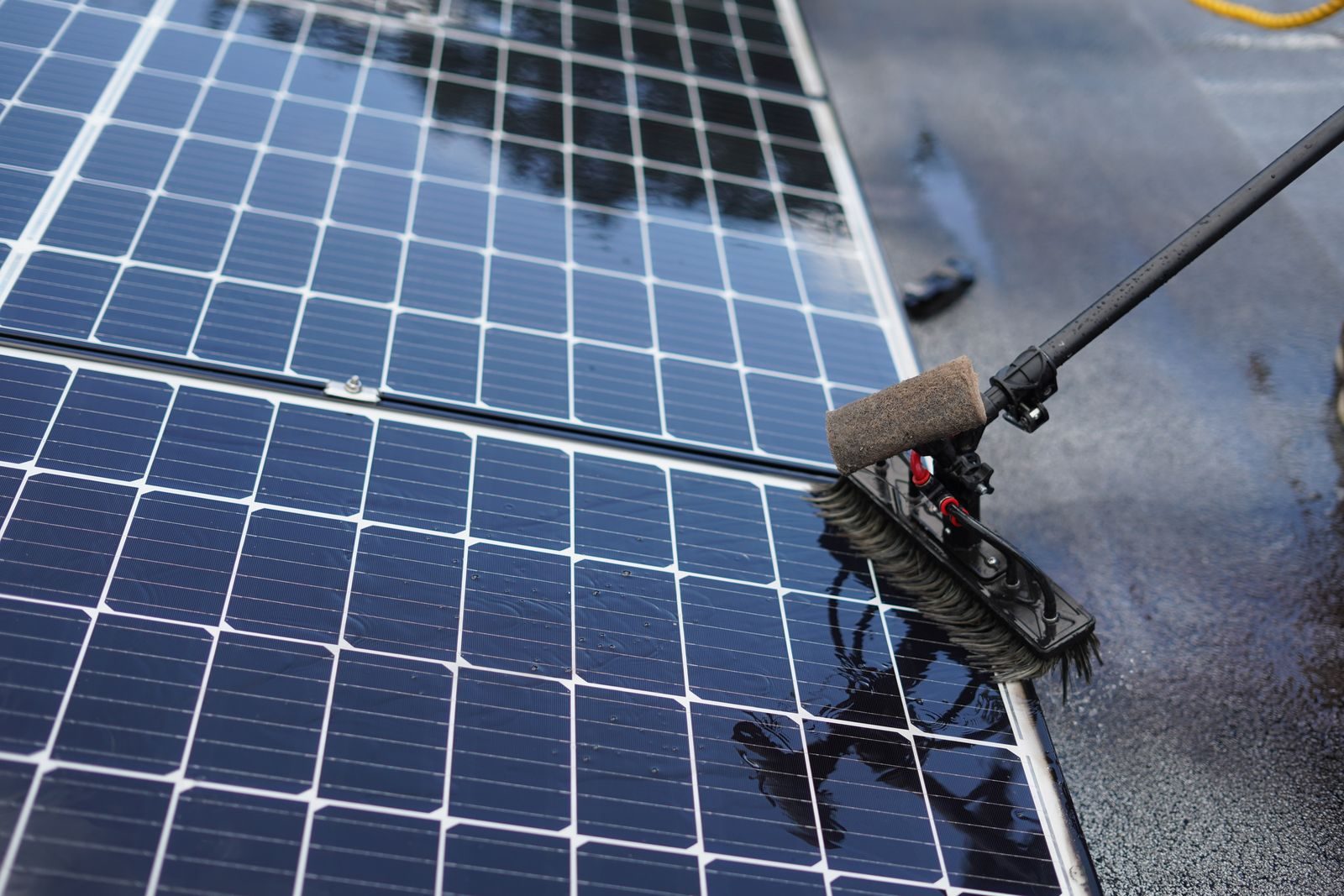 Quarry Management Close-up of solar panel cleaning using a brush tool in Tampa, Florida.